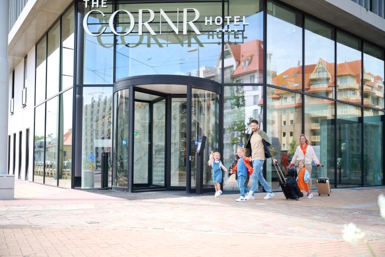 Gezin met twee kinderen voor het hotel